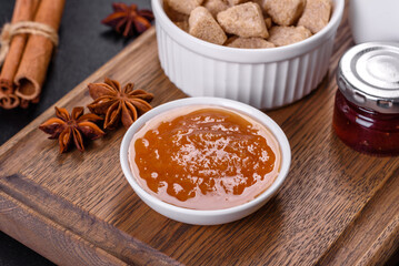Delicious apricot jam, milk and sugar on a wooden cutting board