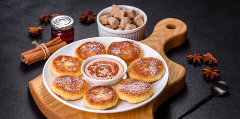 Cottage cheese pancakes with oats, syrniki on a black rustic background