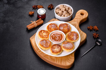 Cottage cheese pancakes with oats, syrniki on a black rustic background