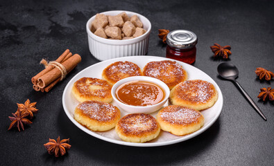 Cottage cheese pancakes with oats, syrniki on a black rustic background