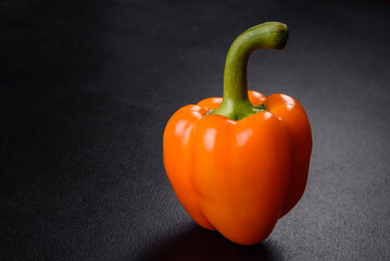 Fresh beautiful bell pepper orange on a dark concrete background