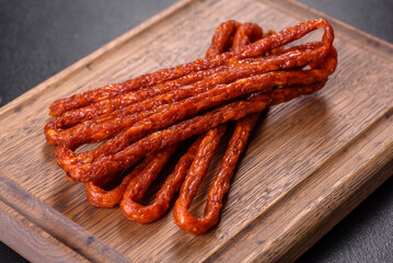 Smoked hunting sausages on a black stone background. Top view. Free copy space