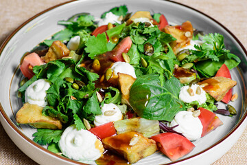 Warm tomato salad with baked vegetables, potatoes, close-up