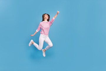 Fototapeta na wymiar Full length profile portrait of active excited lady raise fist look empty space isolated on blue color background