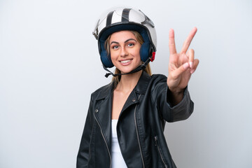 Young caucasian woman with a motorcycle helmet isolated on white background smiling and showing victory sign