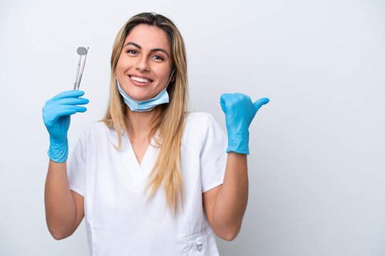 Dentist woman holding tools isolated on white background pointing to the side to present a product