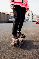 Close up nonconformist unrecognizable person riding longboard skateboarding