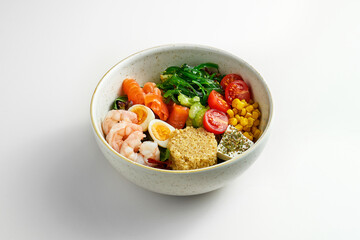 A tasty bowl of tomato, shrimp, salmon and yellow sauce on a gray background. Superfood