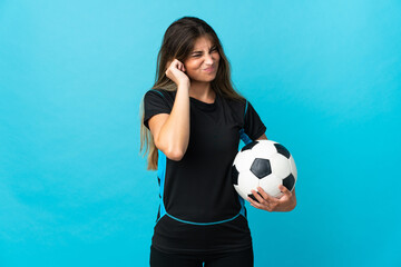 Young football player woman isolated on blue background frustrated and covering ears