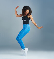She has all the rights moves. Shot of an attractive young woman posing against a gray background.