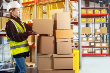 Storekeeper with boxes. Warehouse worker woman. Girl picks up cardboard parcel. Storekeeper on...