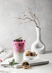 Yogurt, granola with nuts and cherries in a transparent glass. Light and healthy breakfast. Copy space