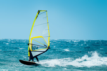 windsurf riding the waves during a windy summer day