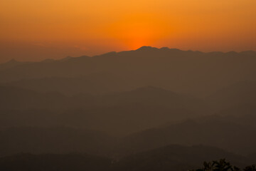 Sunset mountains. Background with orange sky and mountains