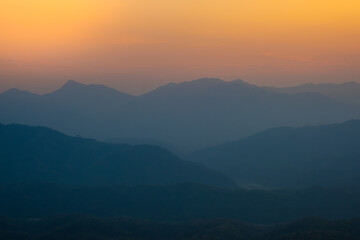 Sunset mountains. Background with orange sky and mountains