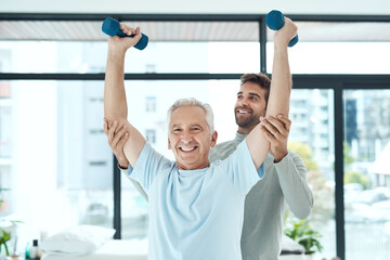 Physiotherapy works. Shot of a friendly physiotherapist helping his senior patient work out with...