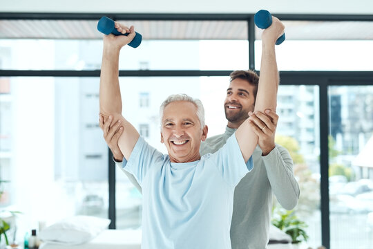 Physiotherapy works. Shot of a friendly physiotherapist helping his senior patient work out with weights.