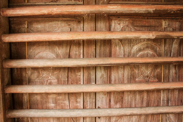 Textured surface of vintage wooden bolts on a door to an old house in Pusing near Ipoh in Malaysia.
