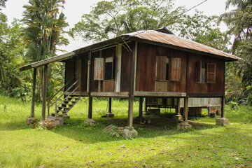 A small rustic wooden shack with a green garden in the heritage town of Ipoh.