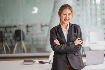 Portraits of beautiful smiling Asian women relax using laptop computer technology while sitting on their desks and using their creativity to work, work from home concept.