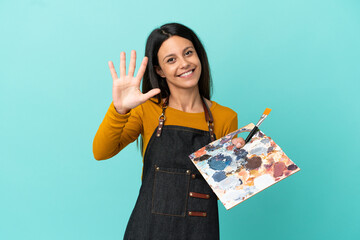 Young artist caucasian woman holding a palette isolated on blue background counting five with fingers