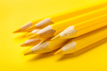 Heap of pencils on yellow background