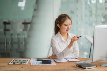 Obraz premium Portraits of beautiful smiling Asian women relax using laptop computer technology while sitting on their desks and using their creativity to work, work from home concept.