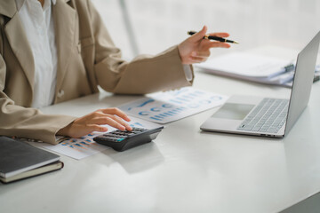Portraits of beautiful smiling Asian women relax using laptop computer technology while sitting on their desks and using their creativity to work, work from home concept.