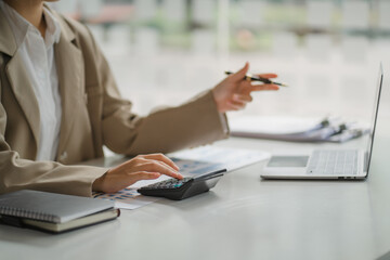 Portraits of beautiful smiling Asian women relax using laptop computer technology while sitting on their desks and using their creativity to work, work from home concept.