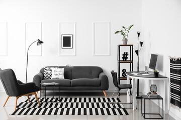 Stylish interior with grey sofa near white wall