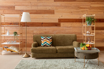 Interior of modern living room with green sofa, pouf and fruit basket