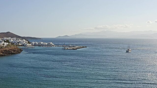 Piso Livadi Paros Greece Aerial v1 cinematic low level drone flying towards a small village town harbor capturing beautiful seascape and townscape in the summertime - September 2021