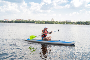 woman rest at paddle boards on a bay or city lake.