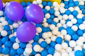 Blue and white plastic balls with purple balloon