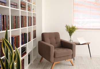 Bookcase with armchair in modern interior of room
