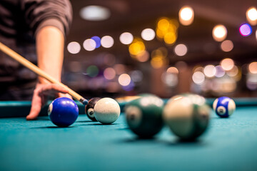 female hand collects colored balls after playing billiards and prepares a new game.
