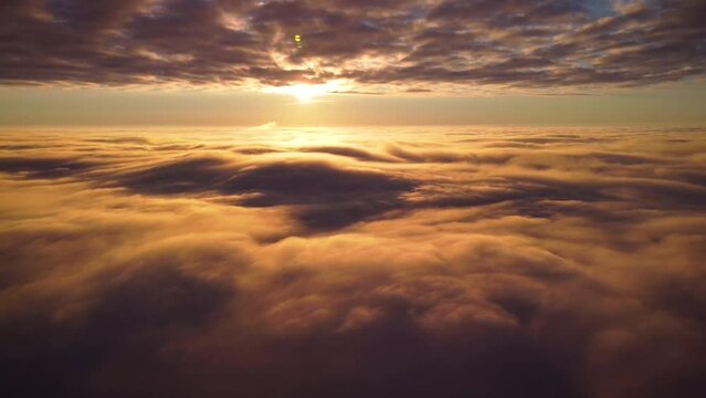Dramatic video of drone flying in clouds. Beautiful sunset in the sky, heaven-like footage above the clouds