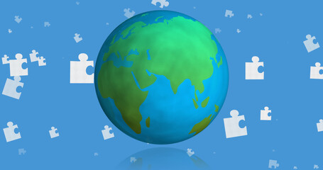 Fototapeta premium Image of blue and white puzzle pieces falling over globe on blue background