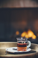 cup of tea on a tray in front of the fireplace. High quality photo