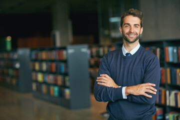 Knowledge really is power. Cropped portrait of a handsome young businessman standing with his arms...