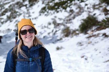 Woman hiking on a sunny day in the winter wilderness