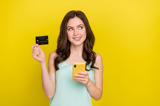 Photo of adorable good mood dreamy female thinking about online nfc transaction isolated on yellow color background