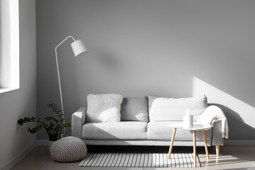 Interior of modern living room with grey sofa, standard lamp and table