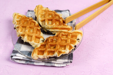 Croffle or Croisant waffle dessert, a marriage between a croissant and a waffle iron. Pink background