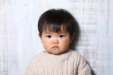 セーターを着た真顔の女の子（オカッパ）。