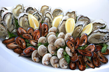 Fresh seafood platter. Venus verrucosa, oysters and hairy mussels with lemons. Puglia food