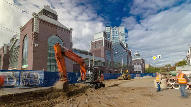 Industrial excavator loading soil material from road construction site into a dumper truck timelapse