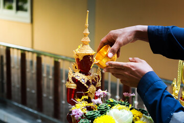 Golden Buddha statue in Buddhism of Thailand with pink lotus shadow. blur background