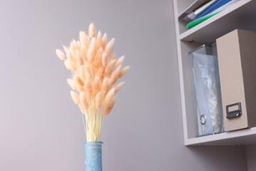 Pink flowers hare tails in blue vase closeup