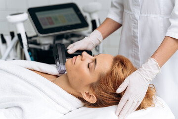 Obraz premium Woman laying at the couch with closed eyes in professional beauty clinic